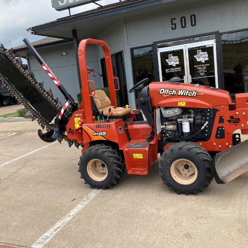 An orange Ditch Witch in the Stellar Rentals Texas parking lot.